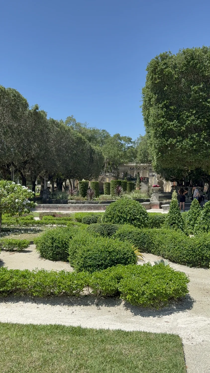 French-style garden of a villa in Marrakech — trimmed box hedges, paths and a fountain