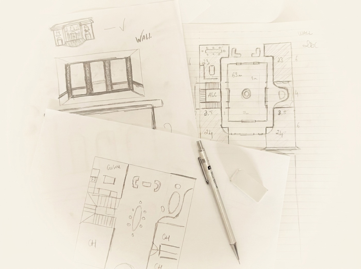 Freehand sketch by Badis: plans and a façade of a villa drawn in pencil, lying on the desk
